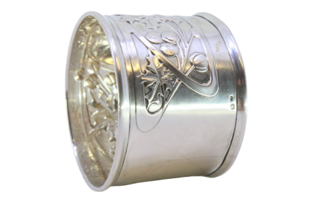  Argola de guardanapo em prata com flores e frutos relevados envolvendo cartela para monograma.